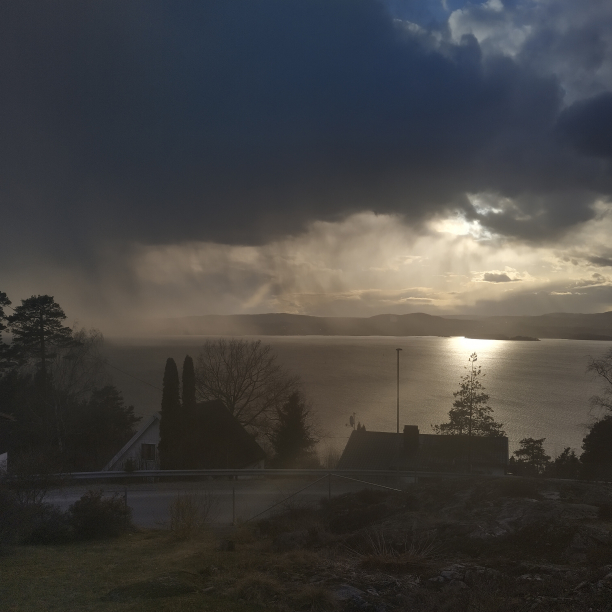 Scenery view of the fjord with the sun peaking out under the clouds.