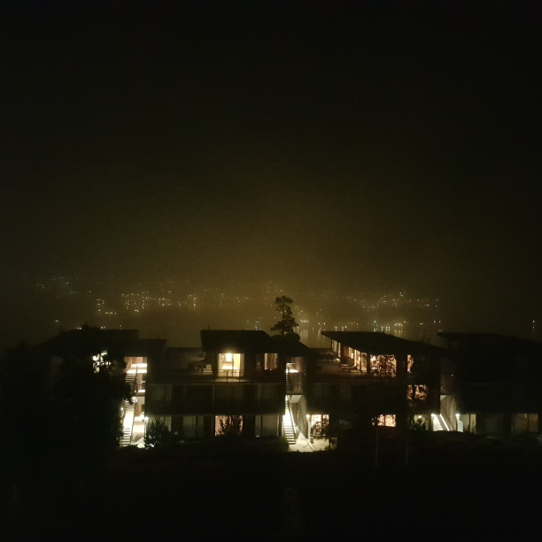 A foggy nightshot of an apartment building.