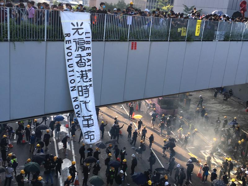 The &quot;Liberate Hong Kong, revolution of our age!&quot; slogan displayed in August 2019 from a footbridge over Harcourt Road in Admiralty.