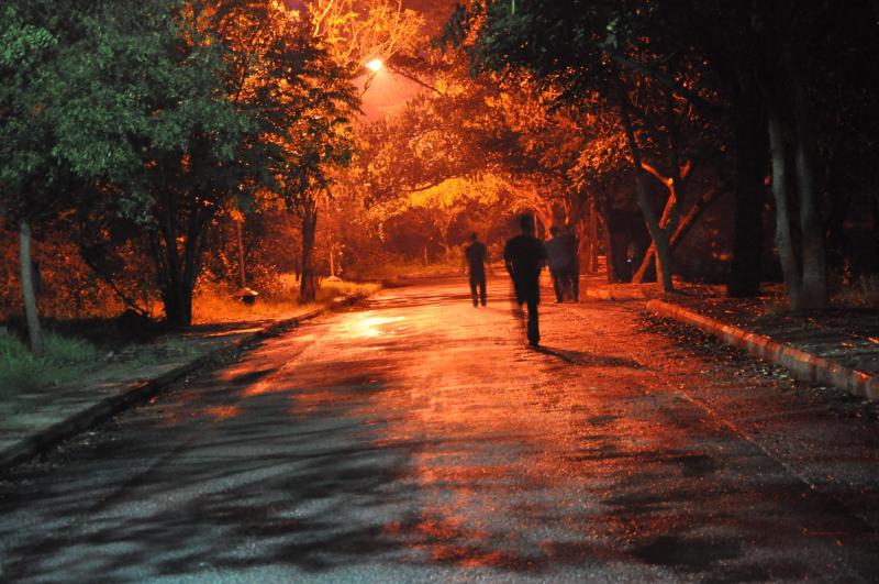 Zombies running through dimly lit street.
