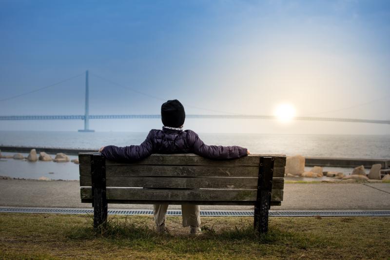 Person sitting on a bench, enjoying the sunset.